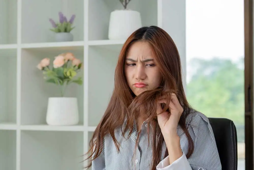 Woman worried about hair fall and damaged hair strands